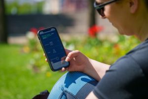 Henkilö katsoo A-kassan ohjeita puhelimellaan