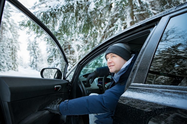 Mies katsoo autosta ulos